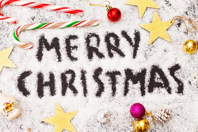 Merry Christmas written in snow by glass ornaments like those Marv steps on in Home Alone