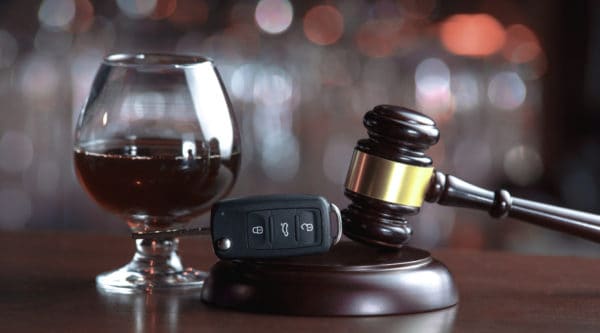 A gavel, a car key, and a glass of brandy.