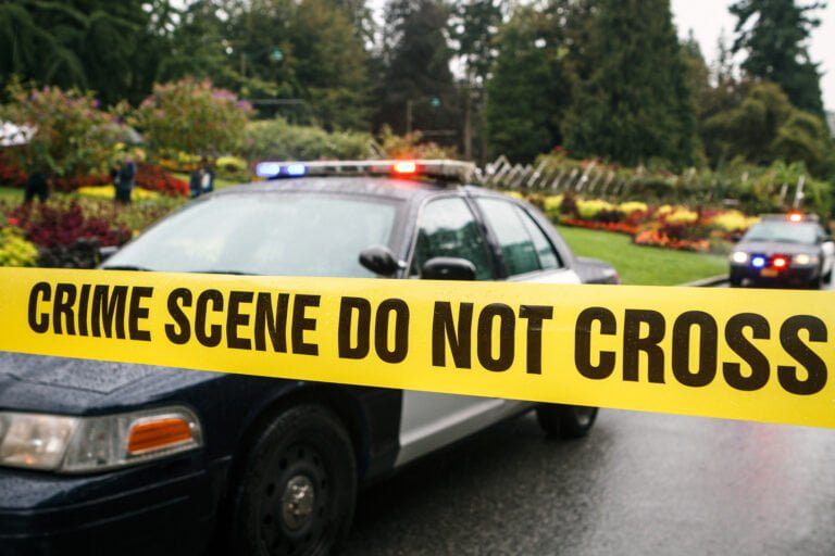 A police car behind police tape to illustrate unauthorized entry into a closed emergency area